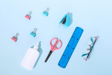 school supplies. The concept of education. Everything for school and office. Pens, pencils, glue, brushes, paints, and everything for studying on a blue background. Flatly.