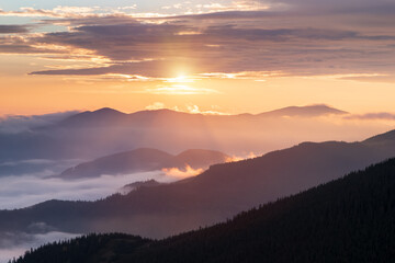 Beautiful sunrise on the spring foggy morning. Landscape with high mountains. Panoramic view. Nature scenery. Wallpaper background. Location Carpathian, Ukraine, Europe. Wallpaper background.