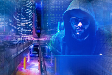 Man computer scientist on background of a night city. Programmer next to skyscrapers. Programmer in sunglasses. Concept - he develops software for city. Creation of software. Work as a programmer