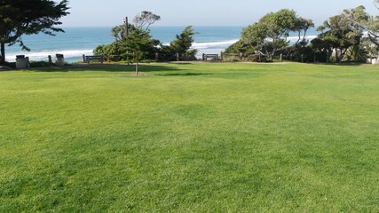 Seagrove recreation beach park in Del Mar, California USA. Seaside garden with lawn in waterfront resort. Green grass and ocean coast view from above. Picturesque coastline vista point on steep hill.
