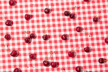 Creative layout with cherries on picnic plaid tablecloth.  Summer fruit concept. Summer or spring...