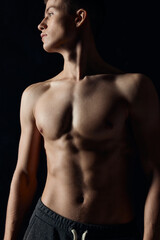 Obraz premium athlete with a naked torso looking to the side on a black background cropped view