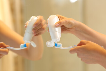 Woman hands putting toothpaste on the brush