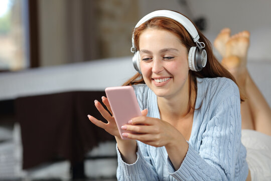 Happy woman listening to music on the floor at home