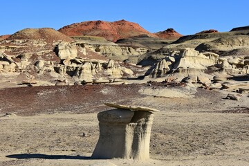 the incredible red hills, badlands, and  colorful, eroded hoodoos on a sunny winter day in the...