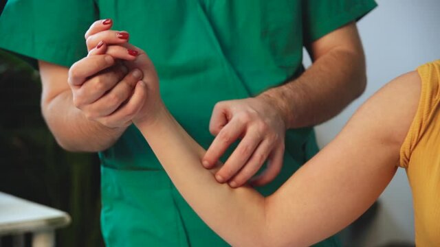 Wrist massage. A male massage therapist puts pressure on a sensitive point on a woman's hand.