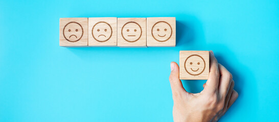 Man hand holding emotion face block. Customer choose Emoticon for user reviews. Service rating,...