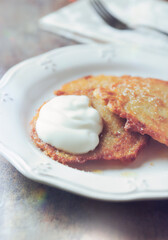 Potato pancakes with sour cream on stone background. Close up. 