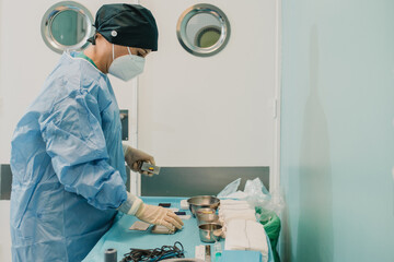 Nurse doctor preparing surgical equipment for operation inside emergency hospital room - Focus on female face