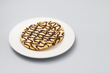 corn crackers with lines of chocolate on white plate