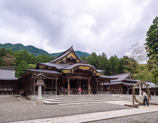Fototapeta na wymiar Main shrine and cogon grass ring (through which people pass as purification rite) (Yahiko shrine, Yahiko, Niigata, Japan)