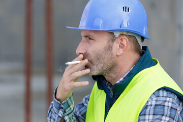 portrait of engineer smoking cigarette outdoors