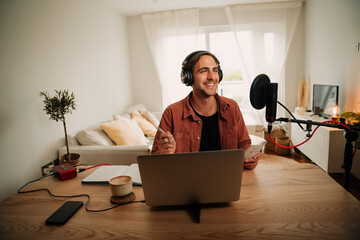 caucasian male popular podcaster conducting live audience while sitting in lunge with fancy set up 