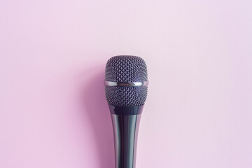 Microphone on a colorful pink background close up. Singing, writing music, karaoke online, creativity, vocals concept, symbol. Singing lessons