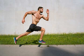 Athletic man sprinting against concrete all in the city