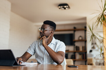 Adult black man, taking a break, at home office.