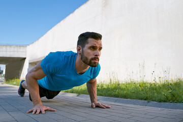 Young man doing pushups outdoors