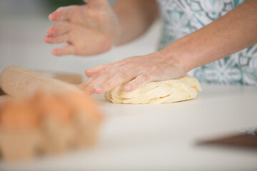 Obraz na płótnie Canvas close up of female hands kneading dough at home