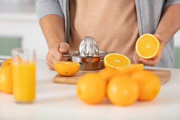 closeup on woman making orange juice