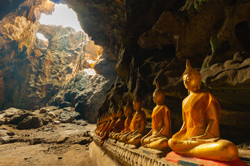 beautiful gold buddha sitting underground in natural dark cave
