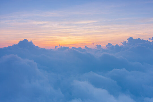 beautiful yellow sunlight of sun while sunrise or sunset with soft blue cloud above peak mountain