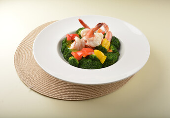 stir fried green broccoli with fresh big tiger prawn and bell pepper in oyster sauce in white plate asian halal menu