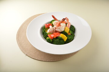 stir fried green broccoli with fresh big tiger prawn and bell pepper in oyster sauce in white plate asian halal menu