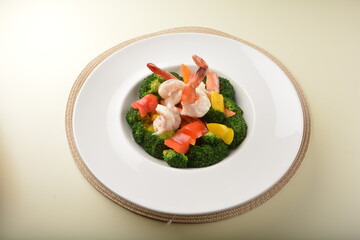 stir fried green broccoli with fresh big tiger prawn and bell pepper in oyster sauce in white plate asian halal menu