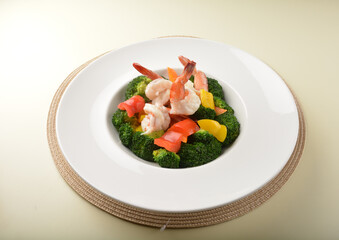 stir fried green broccoli with fresh big tiger prawn and bell pepper in oyster sauce in white plate asian halal menu