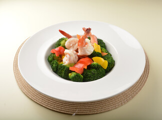 stir fried green broccoli with fresh big tiger prawn and bell pepper in oyster sauce in white plate asian halal menu
