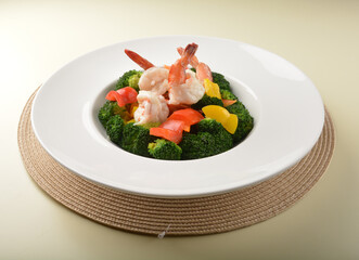 stir fried green broccoli with fresh big tiger prawn and bell pepper in oyster sauce in white plate asian halal menu