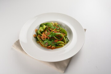 stir fried kai lan vegetable with spicy chilli sambal sauce in plate on white table chinese restaurant asian cafe vegan halal menu