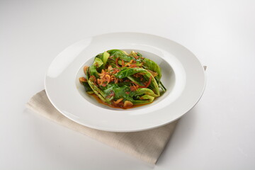 stir fried kai lan vegetable with spicy chilli sambal sauce in white plate asian halal menu