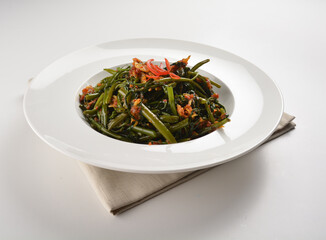 stir fried kang kong vegetable with spicy sambal chilli sauce in plate on white table chinese restaurant asian cafe vegan halal menu