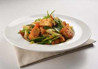 stir fried vegetable with bean curd tofu in spicy sambal chilli sauce in white plate asian halal menu