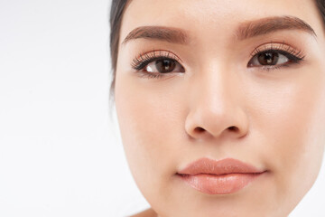 Obraz premium Close-up image of serious young woman with nude make-up and false lashes looking at camera