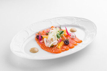 Slices of homemade smoked salmon fillet with olives and onion isolated on white background