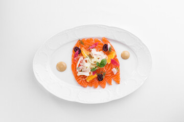 Slices of homemade smoked salmon fillet with olives and onion isolated on white background