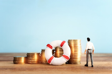 concept image of stacked coins and life bouy over wooden background. banking, funds and assistance...