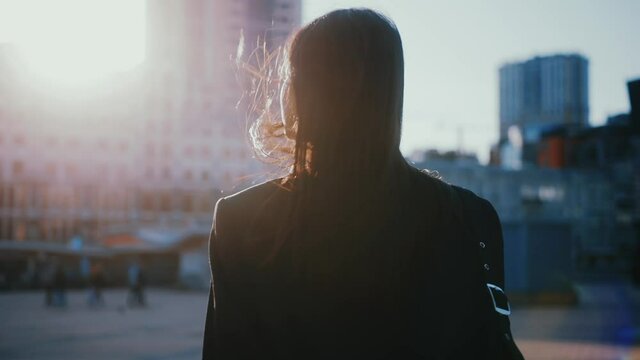 Shot back young woman look around outside business district. Confident girl. Fashion, trendy, girl, urban, outdoor, beauty, businesswoman. Slow motion