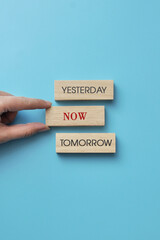 Wooden cubes with inscriptions: yesterday, tomorrow, now. A person's choice of the present moment