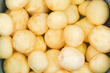 Top view of raw peeled young potatoes in water