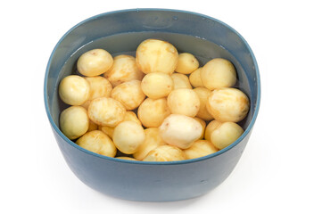 Raw peeled yellow young potatoes in water in the bowl