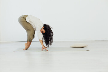 Beautiful woman brunette engaged in yoga asana gymnastics flexibility