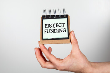 Project Funding. Notebook in woman's hands on a white background