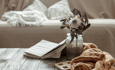 Fototapeta na wymiar Cozy home still life with a book and a dry flower in a vase.