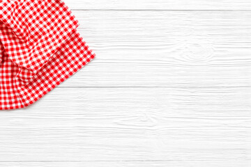 Red picnic cloth on wooden table, top view