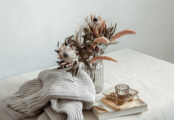 Cozy composition with a bouquet of dried flowers and home decor details. © puhimec