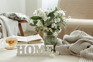 Cozy composition with a cup of tea, a book and the decorative word home.