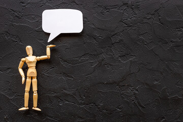 Wooden man figure presenting and showing on speech bubble banner
